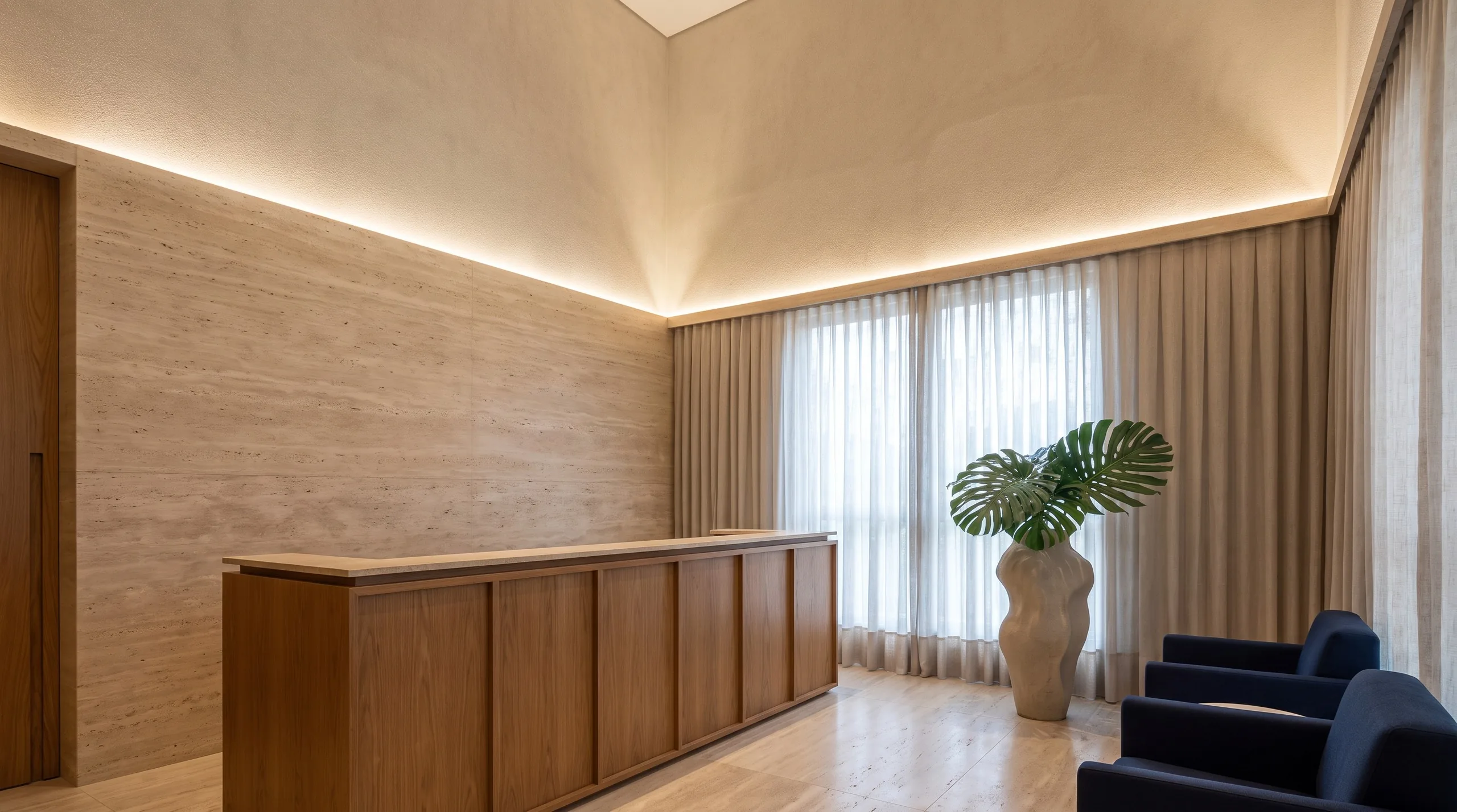 Recepção da clínica, com madeira e iluminação indireta