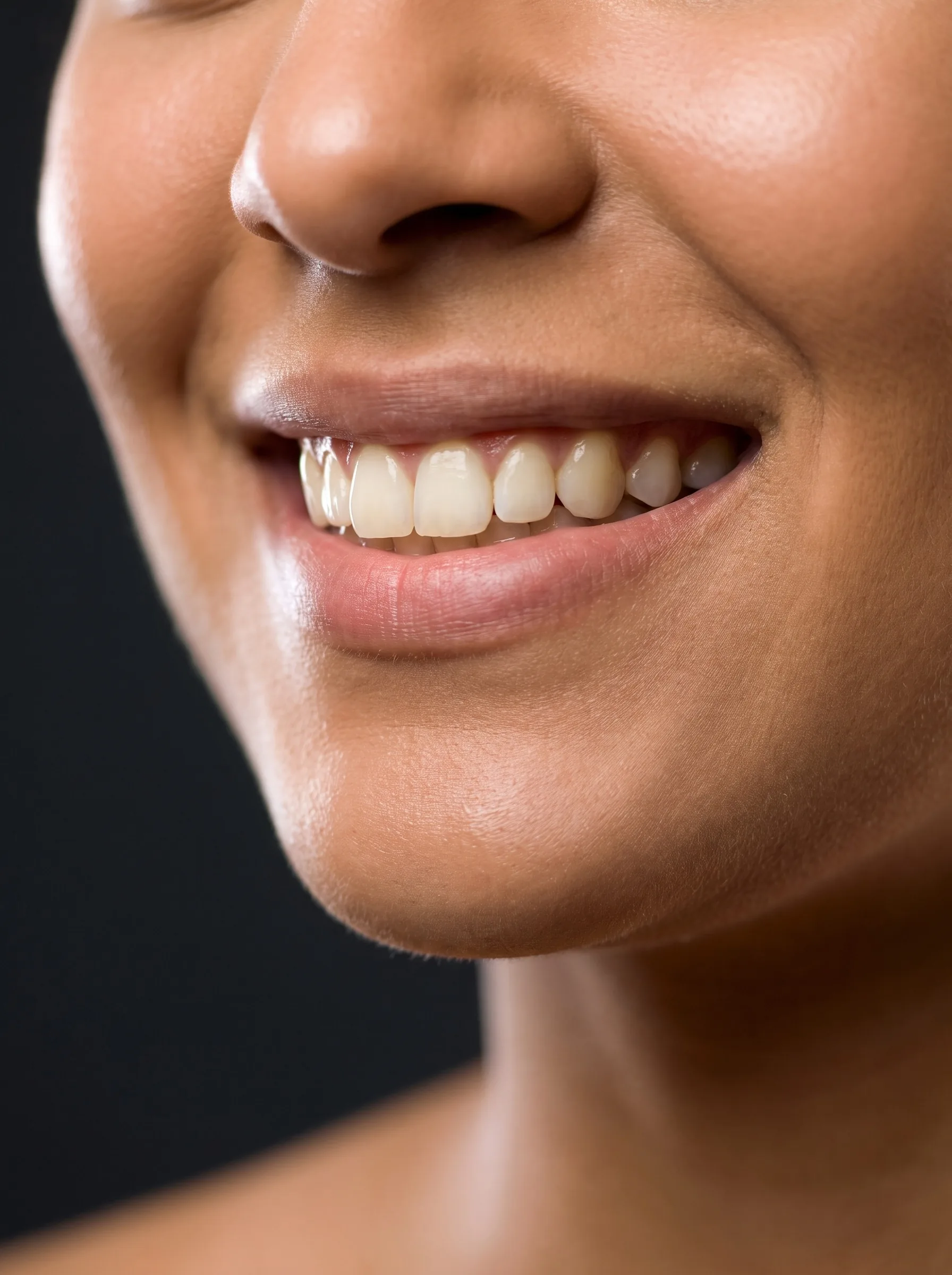 Retrato de paciente sorrindo, em luz baixa